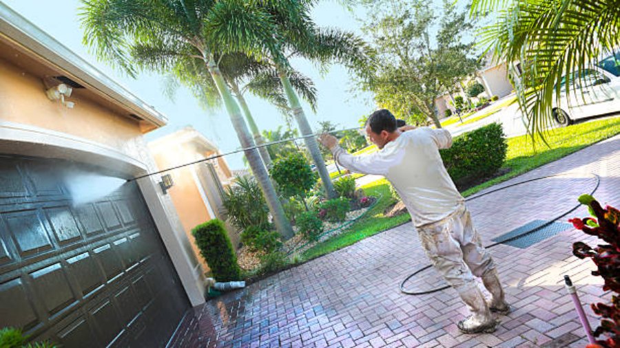 A worker at Lucky Painting Ltd. power washing an upscale home before painting a calgary home