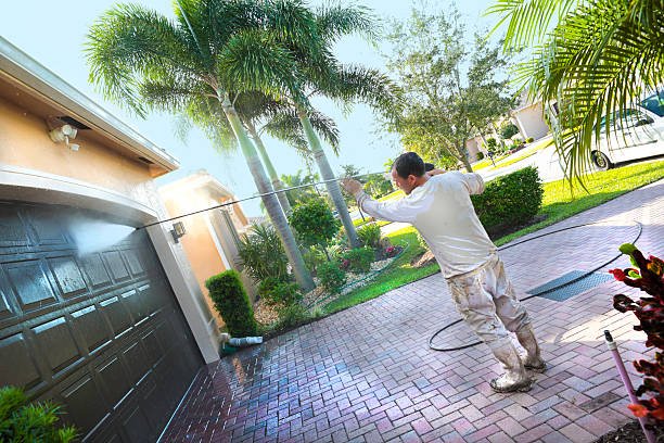 A worker at Lucky Painting Ltd. power washing an upscale home before painting a calgary home